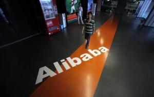 Employee walks pass a logo of Alibaba during a media tour organised by government officials at its headquarters on the outskirts of Hangzhou