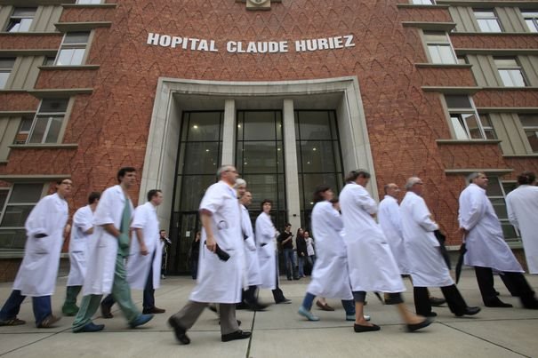 French doctors take part in a silent protest march in the courtyard of Huriez hospital in Lille
