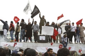 Salafist protesters wave flags during a protest in front of the Tunisian TV headquarters in Tunis